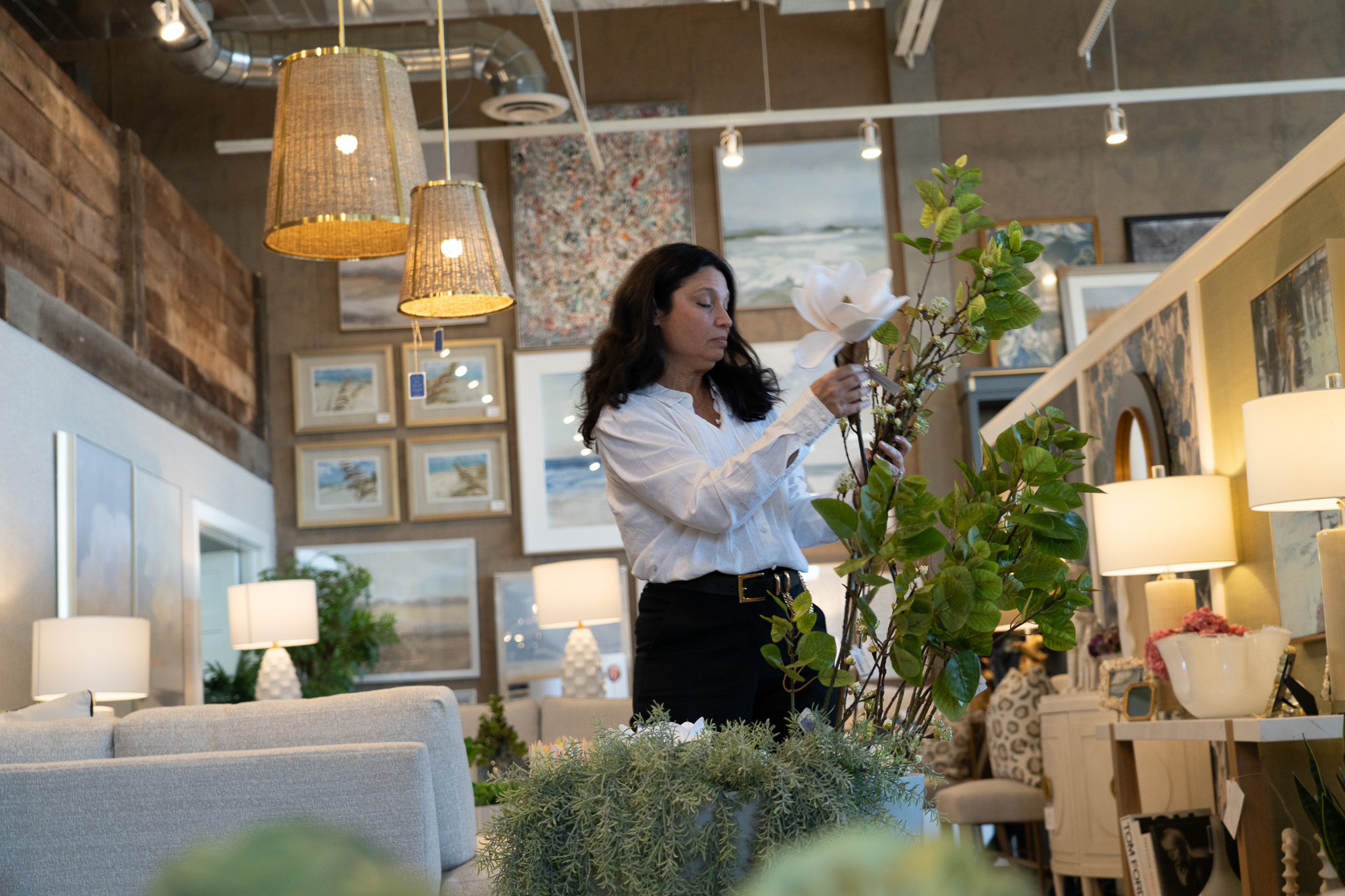 Interior designer arranging flowers inside furniture showroom