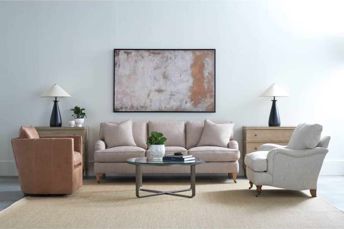 Modern living room with two armchairs, a sofa, two end tables, a coffee table, and an abstract painting